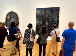 A group of people looking at a large piece of art

Description automatically generated with medium confidence